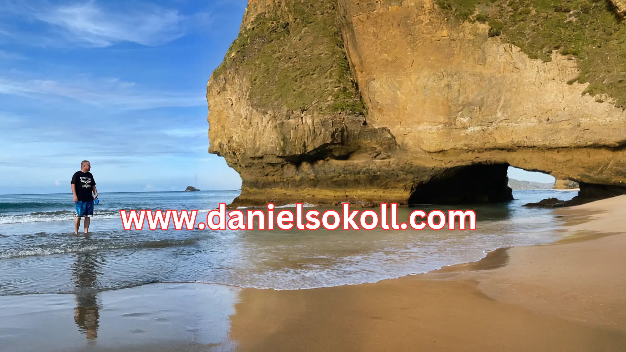 Daniel Sokoll, affiliate marketer, standing on a beach in the Philippines next to a large rock formation with an arch.